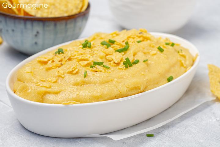 White plate with Linthmais polenta and goat cheese on a white table