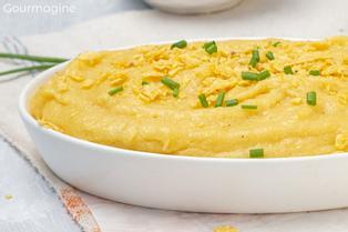 Weisse Schale mit Linthmais-Polenta, die mit Ziegenkäse und Mais-Chips gemischt ist