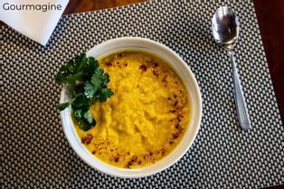 Argentinisches Kürbis-Mais-Püree Humita in einer weissen Schüssel neben einem Löffel