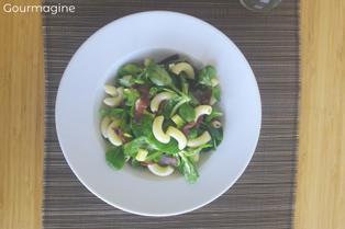 Mache salad with elbow pasta, apples, Appenzell cheese and cured beef in a white plate on a wooden table