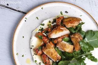 Pouletstücke, Rüebli und Rucola angerichtet auf einem Joghurt-Bett auf einem weissen Teller