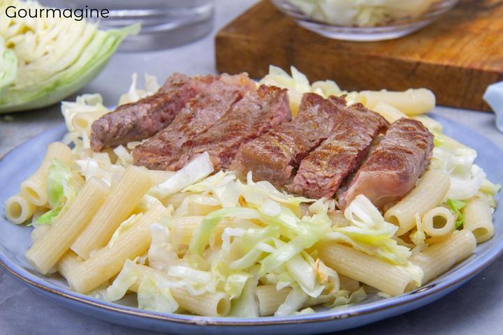 A sliced, fried steak served on a plate with macaroni and cabbage