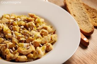 Pouletstücke mit Lauch und Sonnenblumenkerne angerichtet auf einem weissen Teller