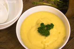 An apple and parsnip soup served in a white bowl