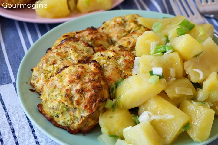 Several zucchini balls and potato pieces arranged on a green plate