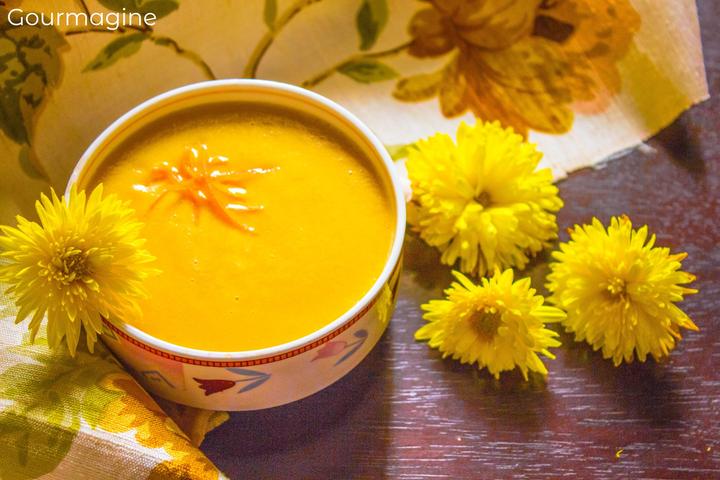 Eine Schüssel gefüllt mit Linsen-Suppe neben gelben Blumen